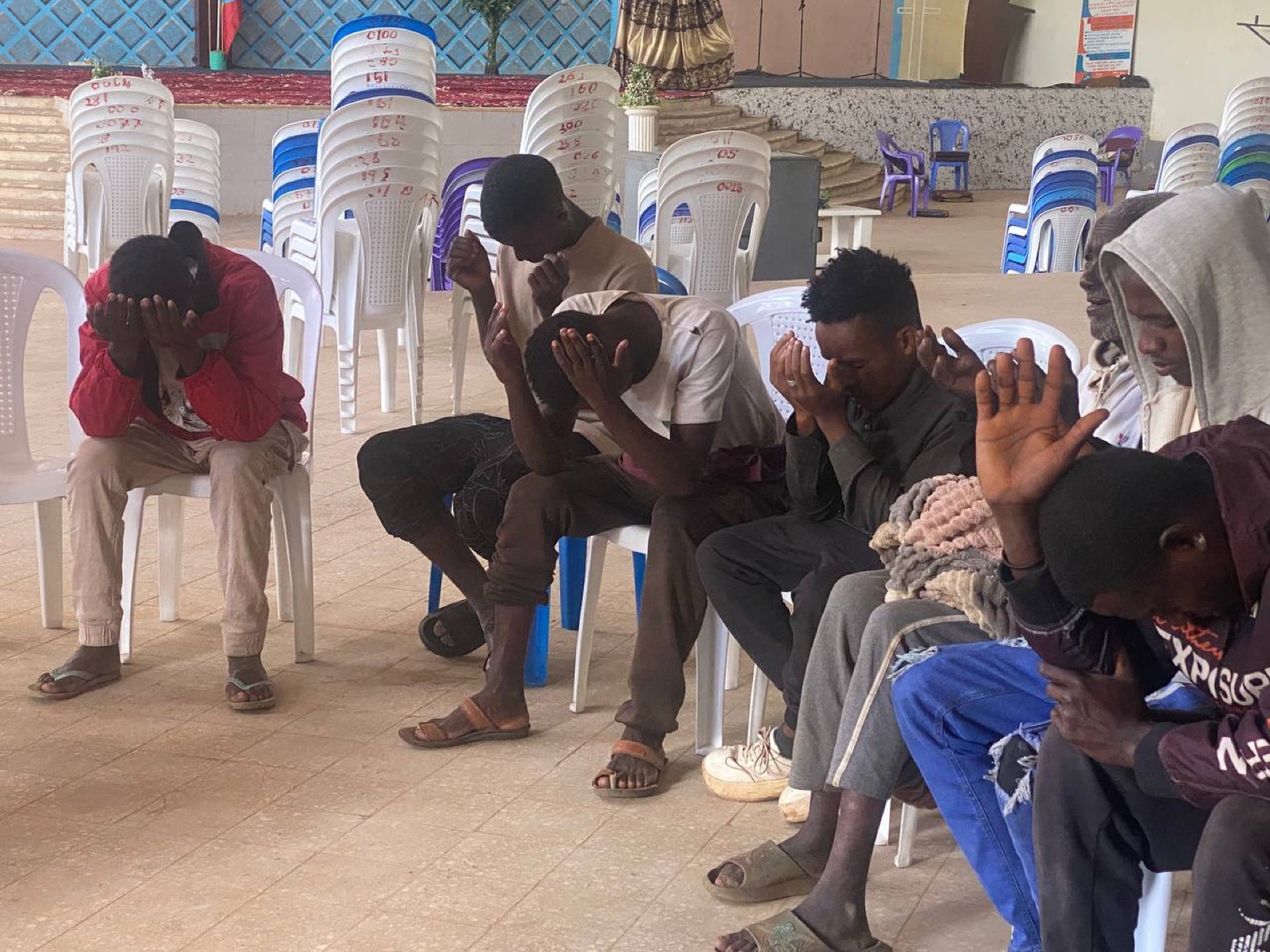A group praying together seated in chairs
