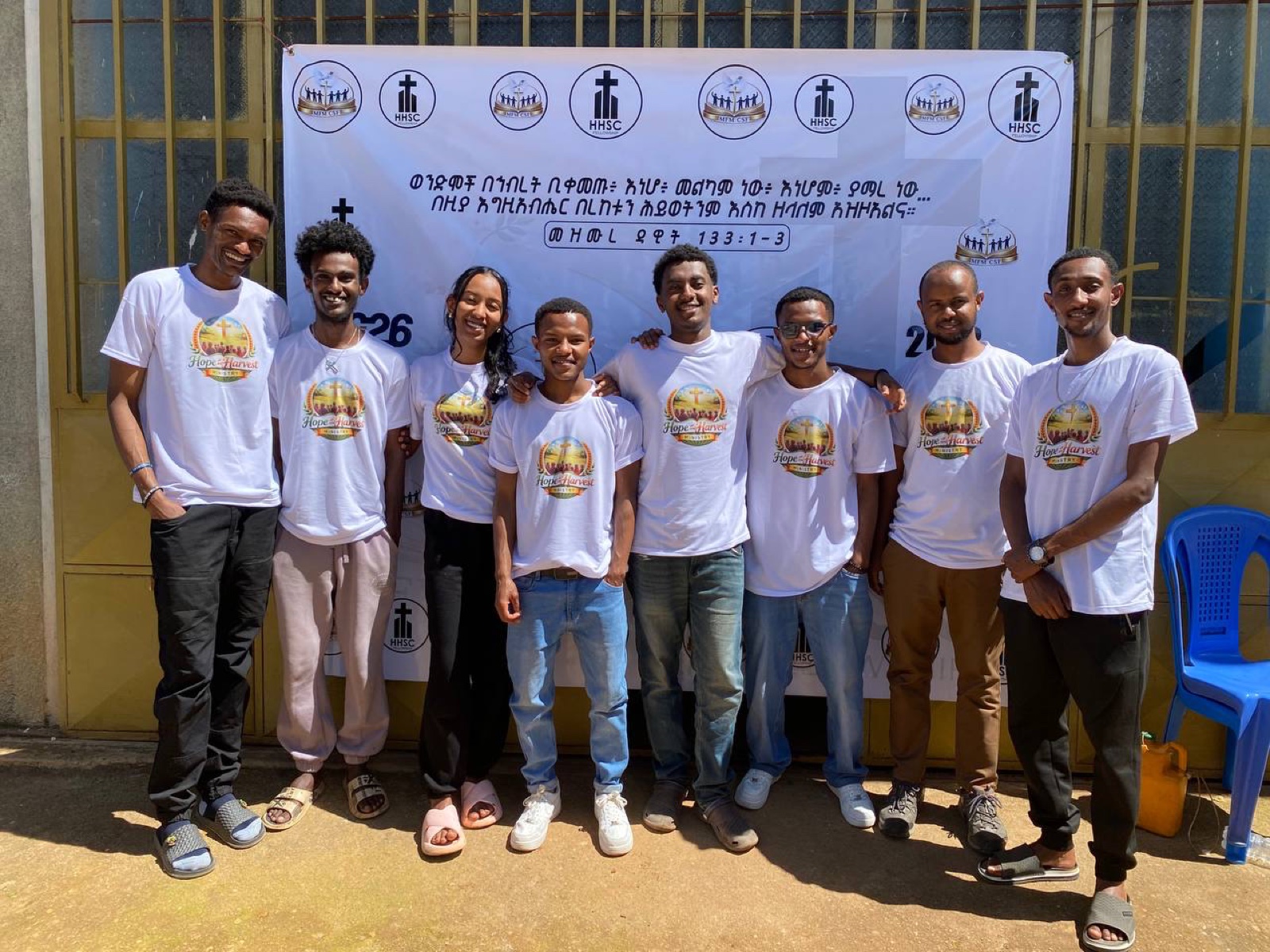 Volunteer team gathered in front of a banner
